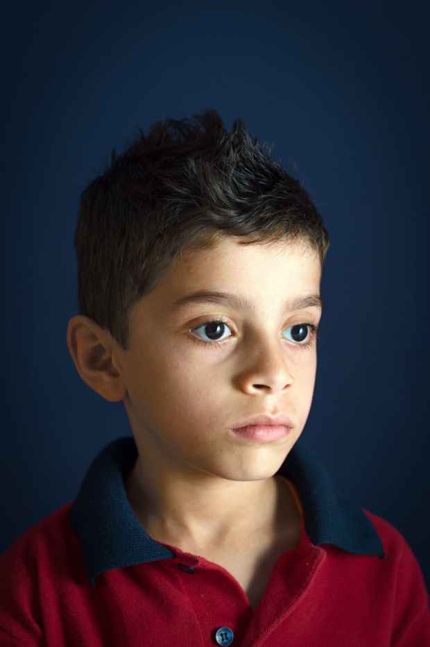 portrait photo of boy wearing red and black polo shirt
