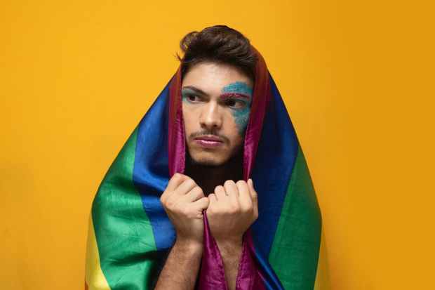 man holding rainbow color flag