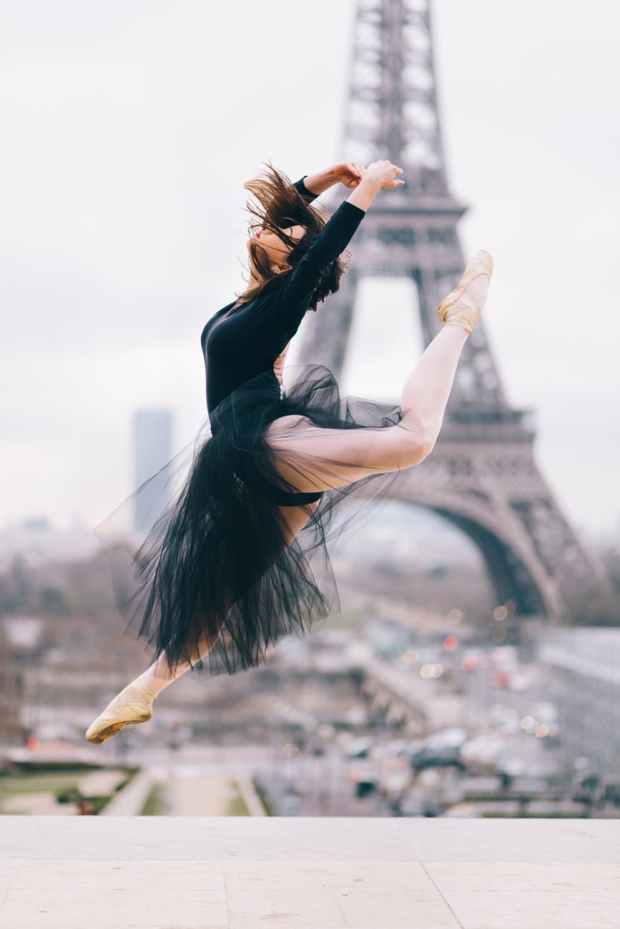 ballet dancer performing stunt with eiffel tower background