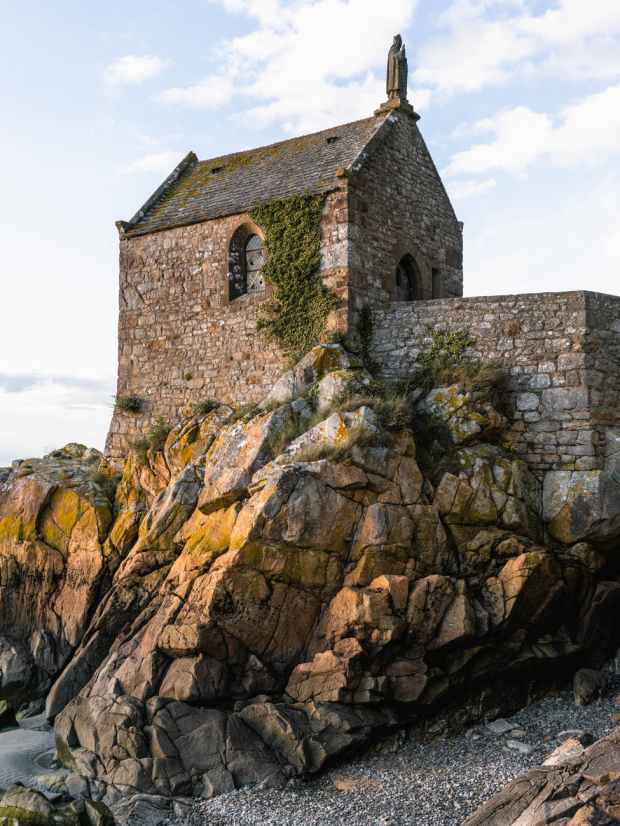 low angle photography of gray stone house on boulder